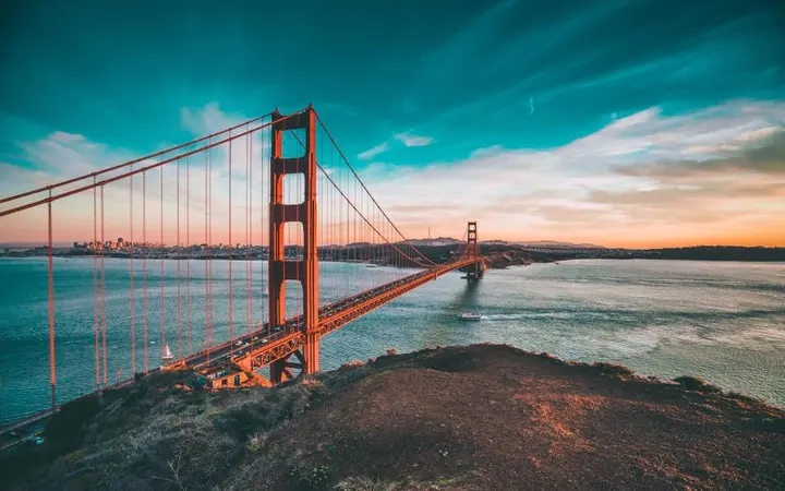 Pogled na sanfranciski Golden Gate most ispod oblaka u prirodnom krajoliku.