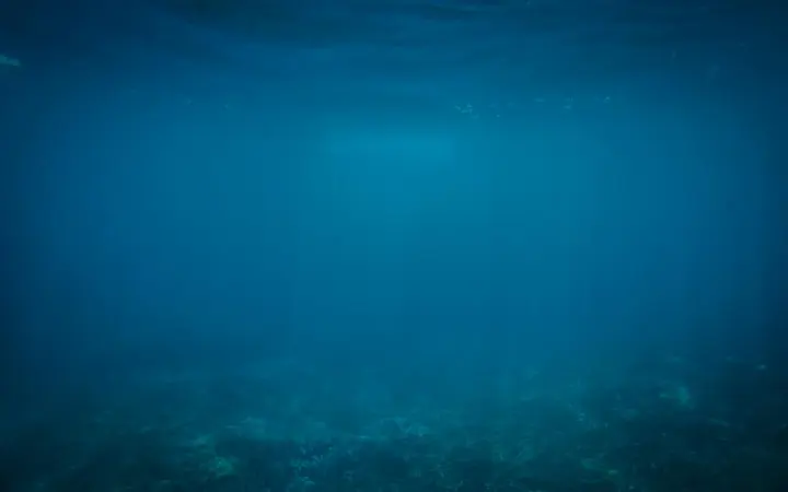 Plavo more ispod površine s vidljivim valovima i dubokim plavetnilom.