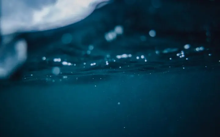 Plava morska površina s mjehurićima u prirodnom krajoliku oceana.