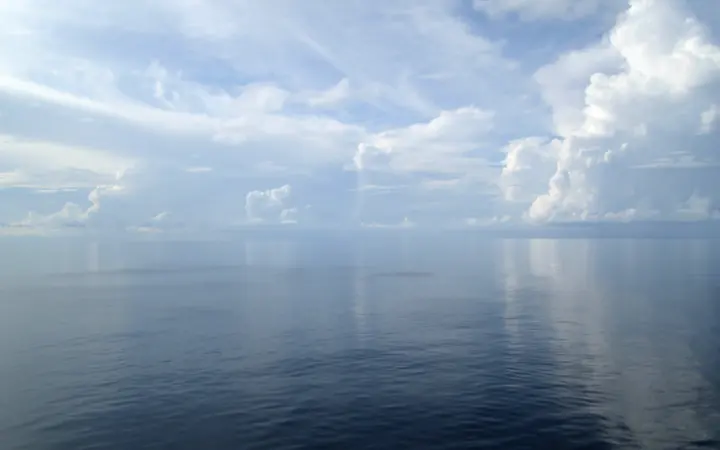 Blago oblačno nebo iznad oceana u prirodnom ambijentu bez jakih vremenskih utjecaja.
