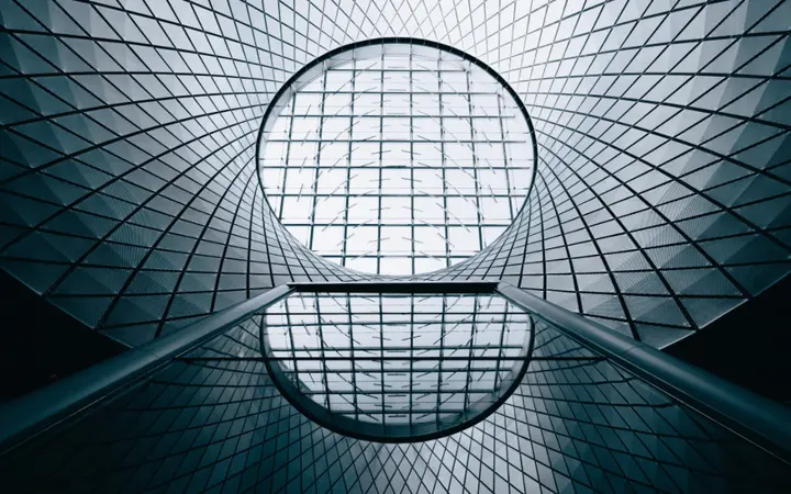 Zgrade s geometrijskim oblicima i industrijskim stilom dominiraju gradskim pejzažem pod dnevnim svjetlom.