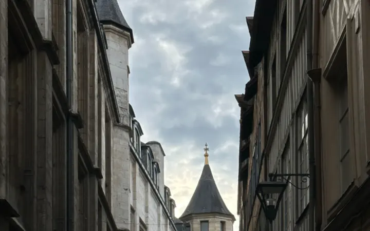 Ulica s drevnim zgradama koje stvaraju skladnu europsku gradsku atmosferu pod vedrim nebom.