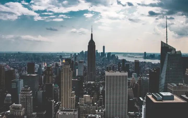 Visoke zgrade u centru grada pod oblacima stvaraju dinamičnu urbanu panoramu New Yorka.