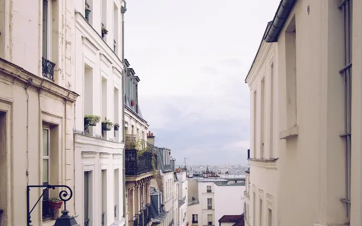 Stare zgrade s balkonima u pariškom kvartu Montmartre pod dnevnim svjetlom.