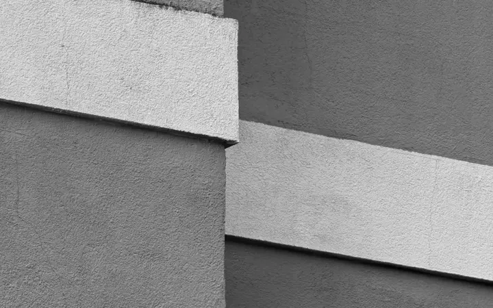 Crno-bijela apstraktna kompozicija gradske zgrade s naglašenim arhitektonskim detaljima.