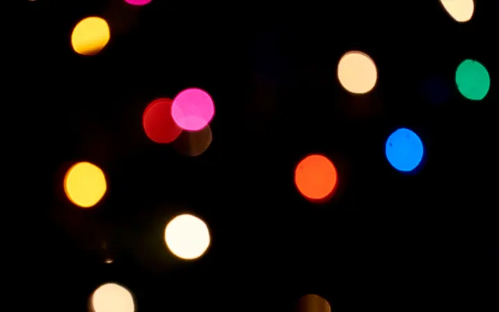 Svjetlucavi i zamućeni bokeh krugovi u svijetlim tonovima stvaraju blagdanski i proslavni ugođaj.