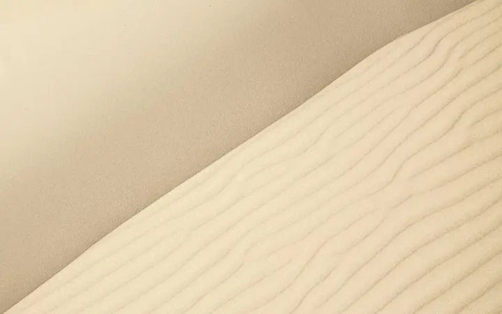Jednostavni uzorci i prirodne bež nijanse stvaraju minimalistički prikaz pustinje.