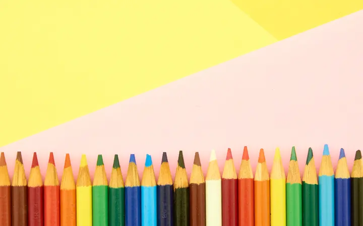 Prikaz šarenih bojica složenih zajedno, s jasnim detaljima i živim bojama koje odražavaju dječju radost i kreativnost.