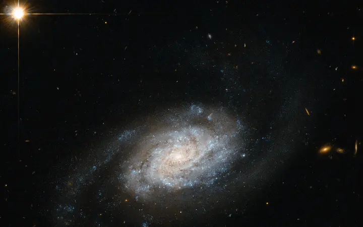 Spiralna galaksija NGC 3455 sa svijetlim plavim krakovima na tamnom svemirskom nebu.