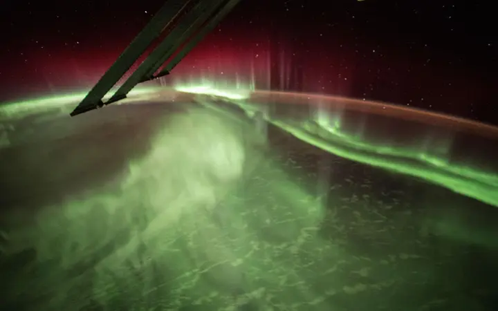 Noćni prikaz s ISS-a prikazuje svjetlosne pojave Aurora Borealis iznad Zemljine atmosfere.