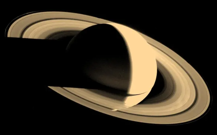Pogled na planet Saturn s jasno definiranim prstenovima uokolo, prikazan u prirodnim bojama i svjetlu.