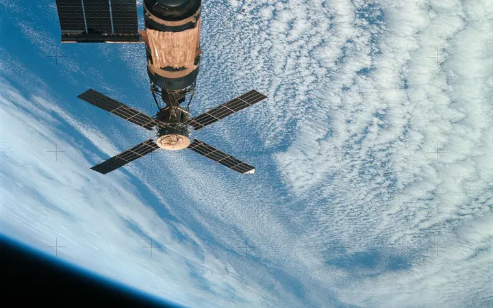 Pogled iznad svemirske stanice Skylab u Zemljinoj orbiti s detaljima modro-zelene Zemlje u pozadini.