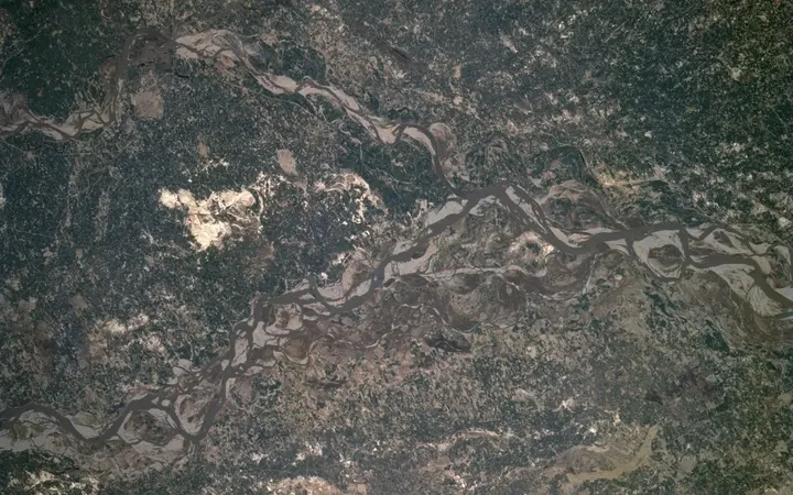 Pogled na Zemlju tijekom misije STS-75 s detaljima atmosfere i površine u plavim i zelenim tonovima.