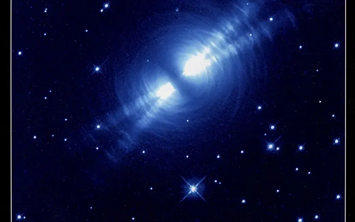 Maglica Egg Nebula prikazana je u crvenim nijansama s jasno vidljivim složenim oblicima na tamnoj pozadini.
