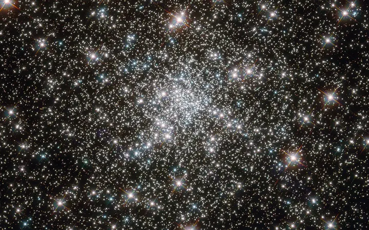 Zvjezdani skup NGC 6752 prikazan je kao skup dragulja u svemiru s plavim i žutim nijansama.
