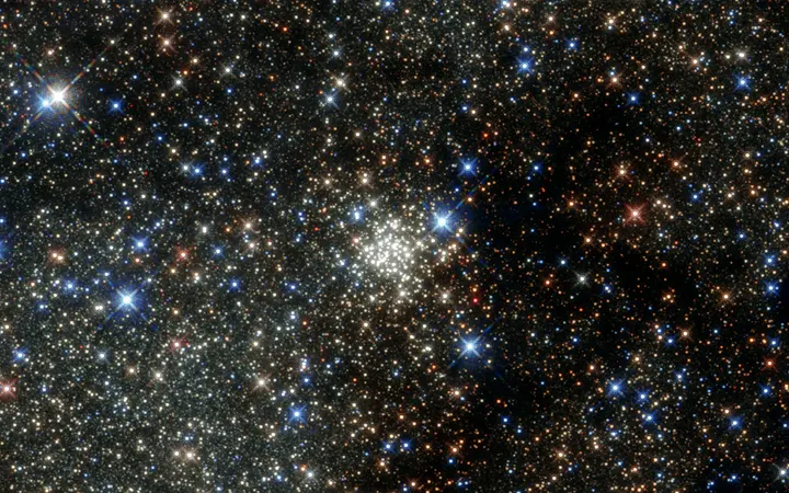 Arches Cluster prikazan je kao gusto naseljeni skup zvijezda u svijetlim tonovima na tamnoj pozadini.