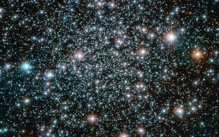 Globularni skup starih zvijezda s metalnim sjajem u dubokim nijansama plave i bijele boje snimljen Hubble teleskopom.
