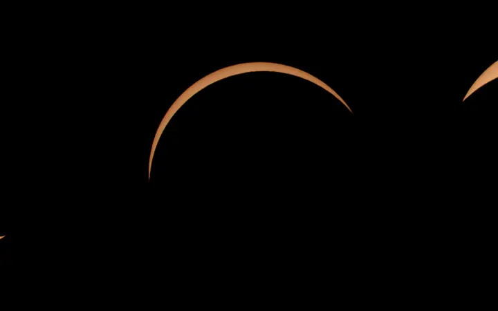 Kolaž devet fotografija prikazuje promjenu djelomične prema totalnoj pomrčini Sunca kod Bannera u Wyomingu.
